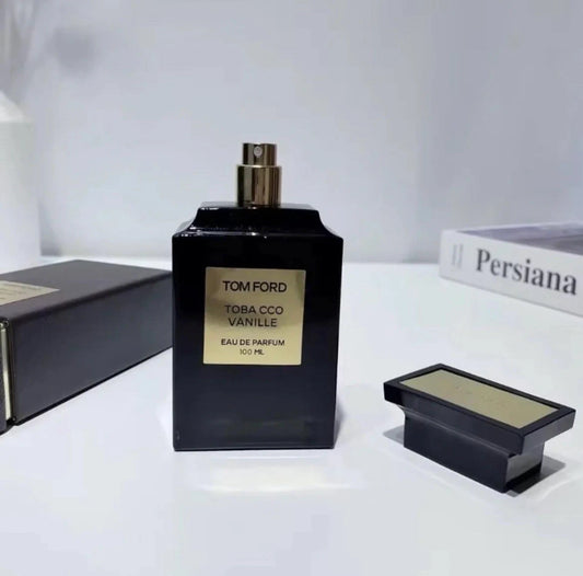 Tom Ford Tobacco Vanille perfume bottle on a white surface with a book in the background