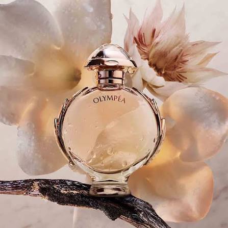 Perfume bottle labeled 'Olympea' with flowers in the background