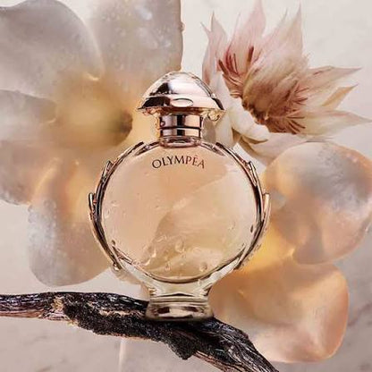 Perfume bottle labeled 'Olympea' with flowers in the background