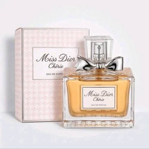 Olympéa Eau de Parfum by Paco Rabanne in a 80ml box. The packaging features a peach-orange background with a cream-colored angel wing design and a dark brown banner across the center displaying the brand name 'OLYMPÉA'.