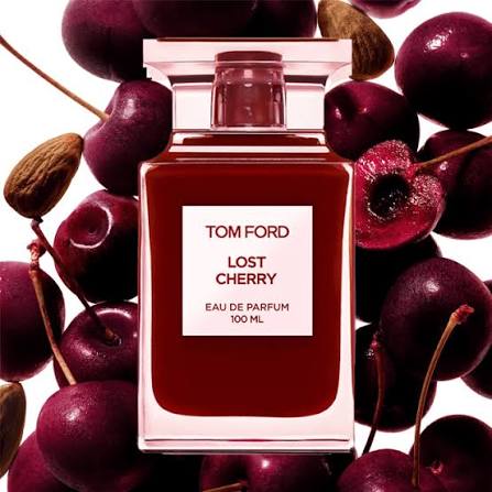 Tom Ford Lost Cherry perfume bottle surrounded by cherries and almonds on a white background