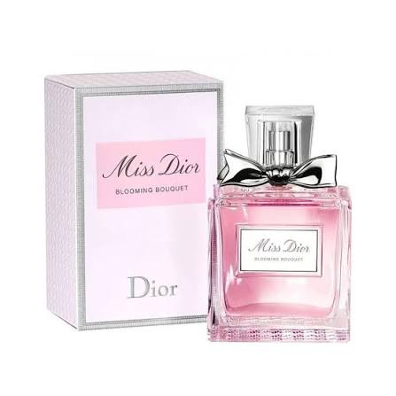 Dior Miss Dior Blooming Bouquet perfume bottle with pink liquid and silver bow, shown next to its light pink and white packaging box on a white background.