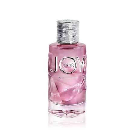 Dior Joy Eau de Parfum in a pink faceted glass bottle with a textured silver cap, shown on a white background with a soft reflection.