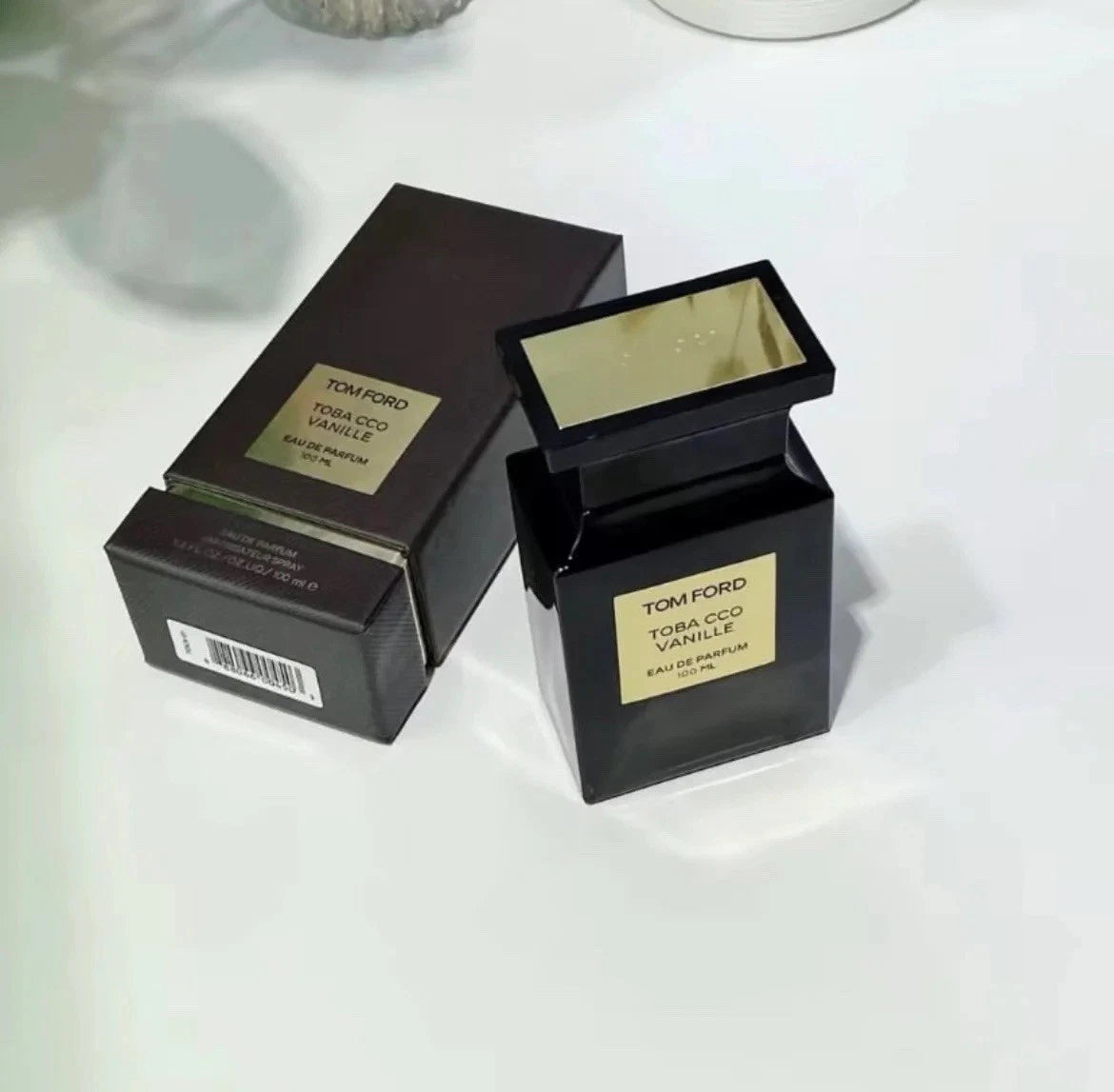 Tom Ford perfume bottle and box on a white surface